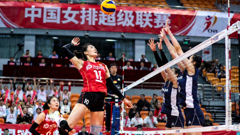中国女排超级联赛比赛现场，女排运动员在排球场上扣球得分